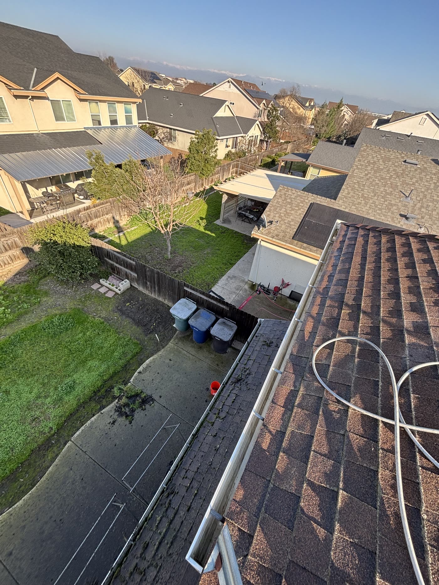 The same gutter run after hand clearing, empty and draining freely