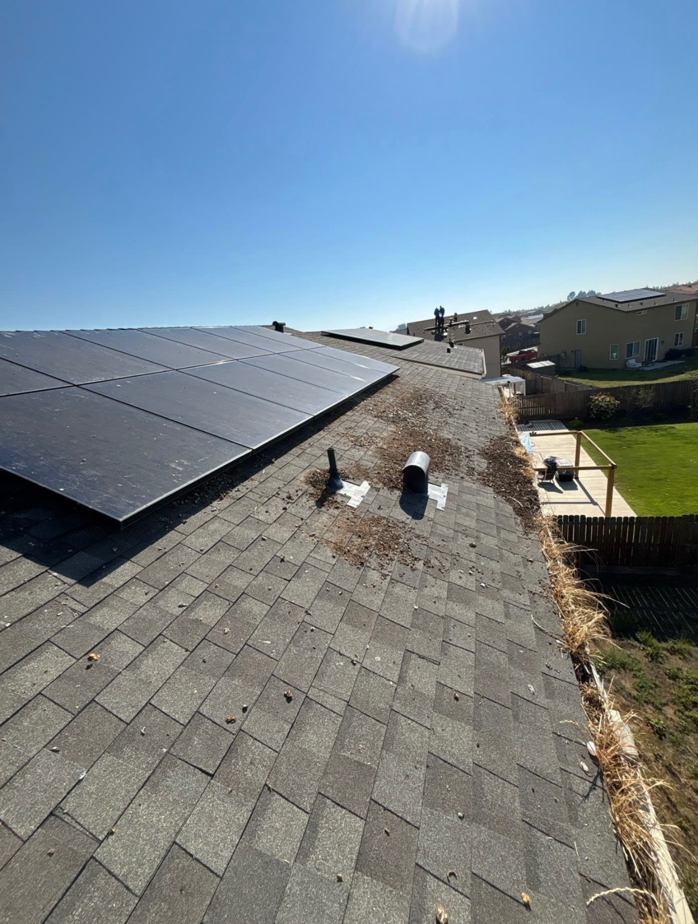 Solar panels on a composition shingle roof coated in grey dust and grime