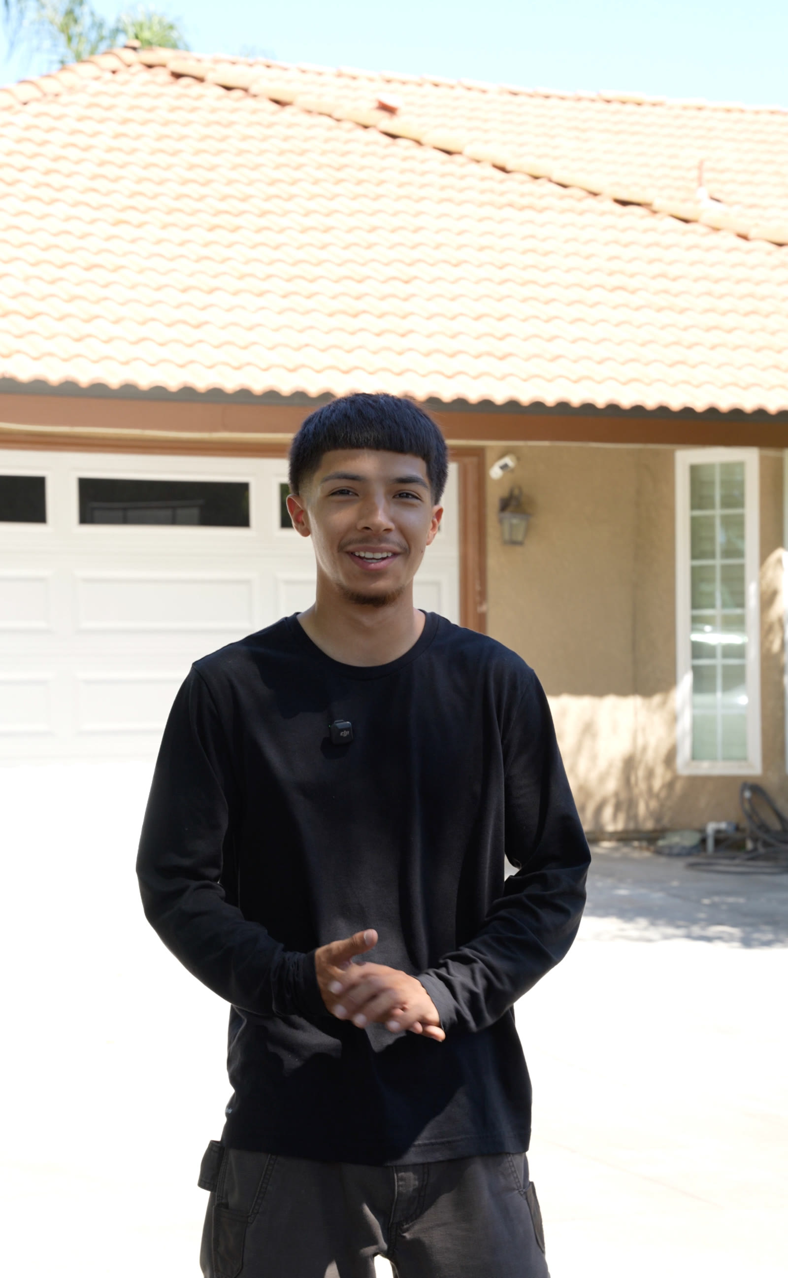A Prestige Pressure Washing crew member standing in front of a residential home