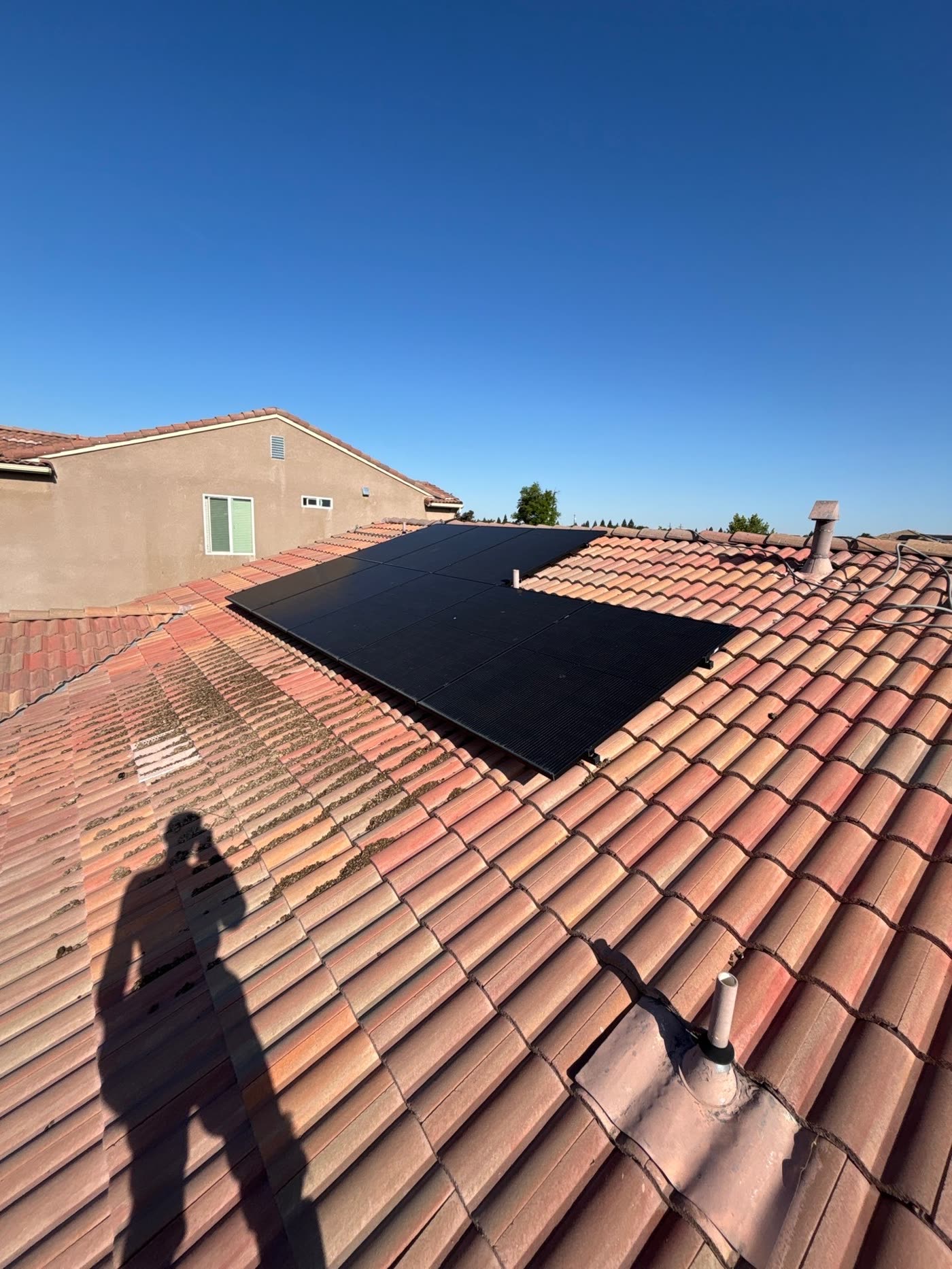Solar panels on a tile roof dulled by a heavy layer of dust and water spotting
