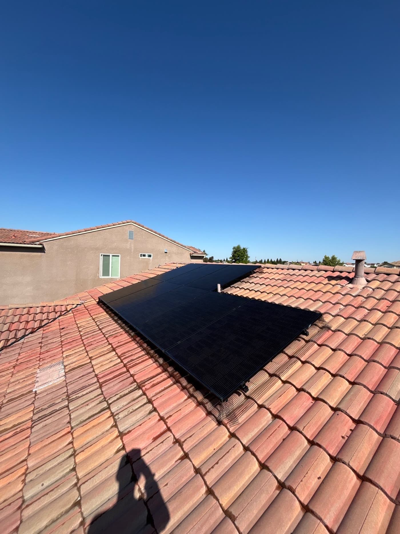 The same solar panels after cleaning, with clear dark glass reflecting the sky
