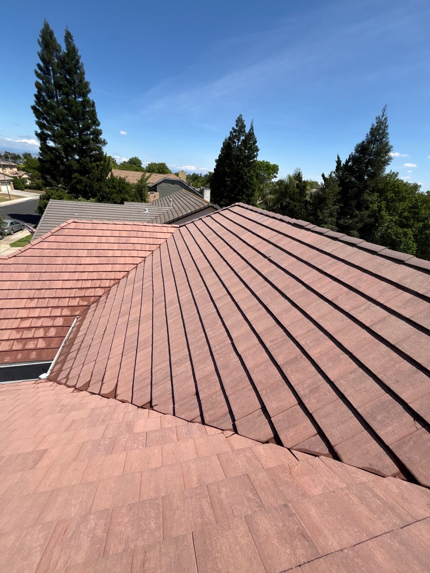 The same tile roof after a soft wash, with the original terracotta color restored and the moss gone